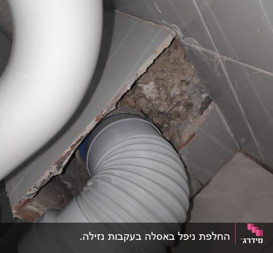 צינור פלסטיק גמיש מחובר לקיר שבור